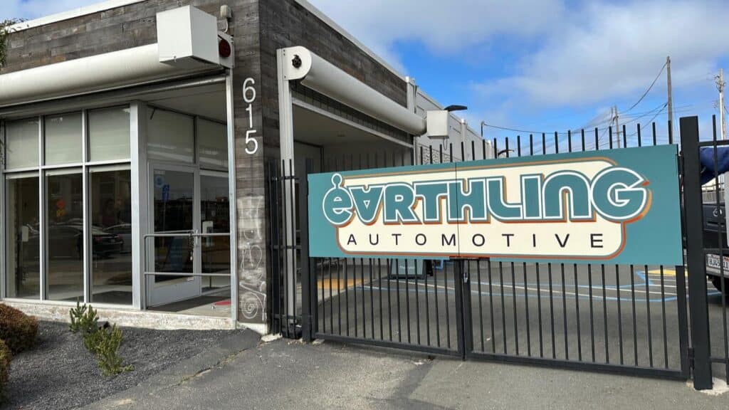 Image showcasing Earthling Automotive front entrance with logo on fence