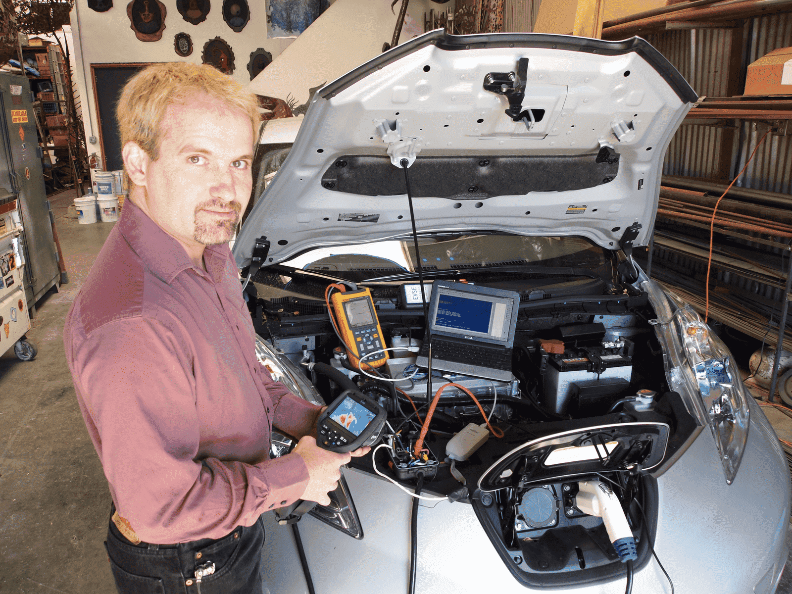 Image showcasing Phil Sadow, guest of Earthling Meet-Up in San Francisco on Sept 16 2023, running a diagnostic on a Nissan Leaf electric car