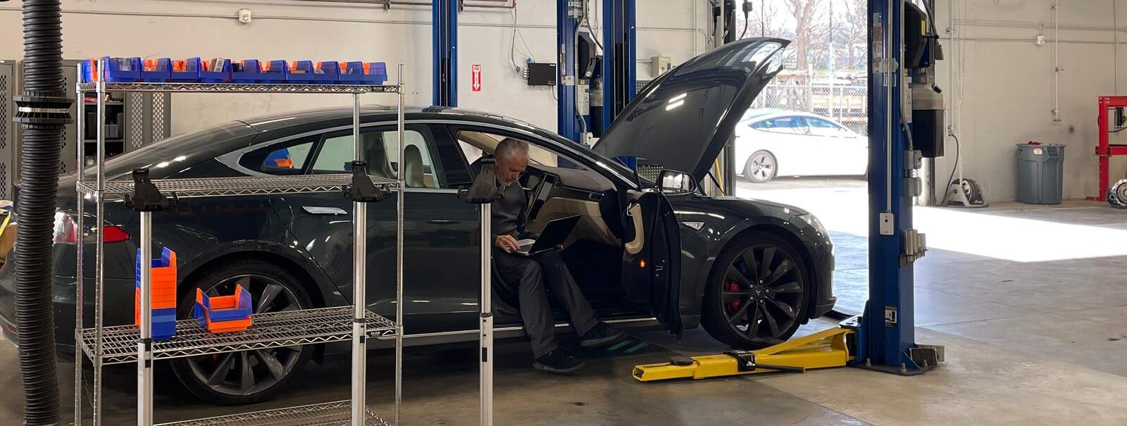 Image showcasing Earthling Automotive technician servicing a Tesla Model 3