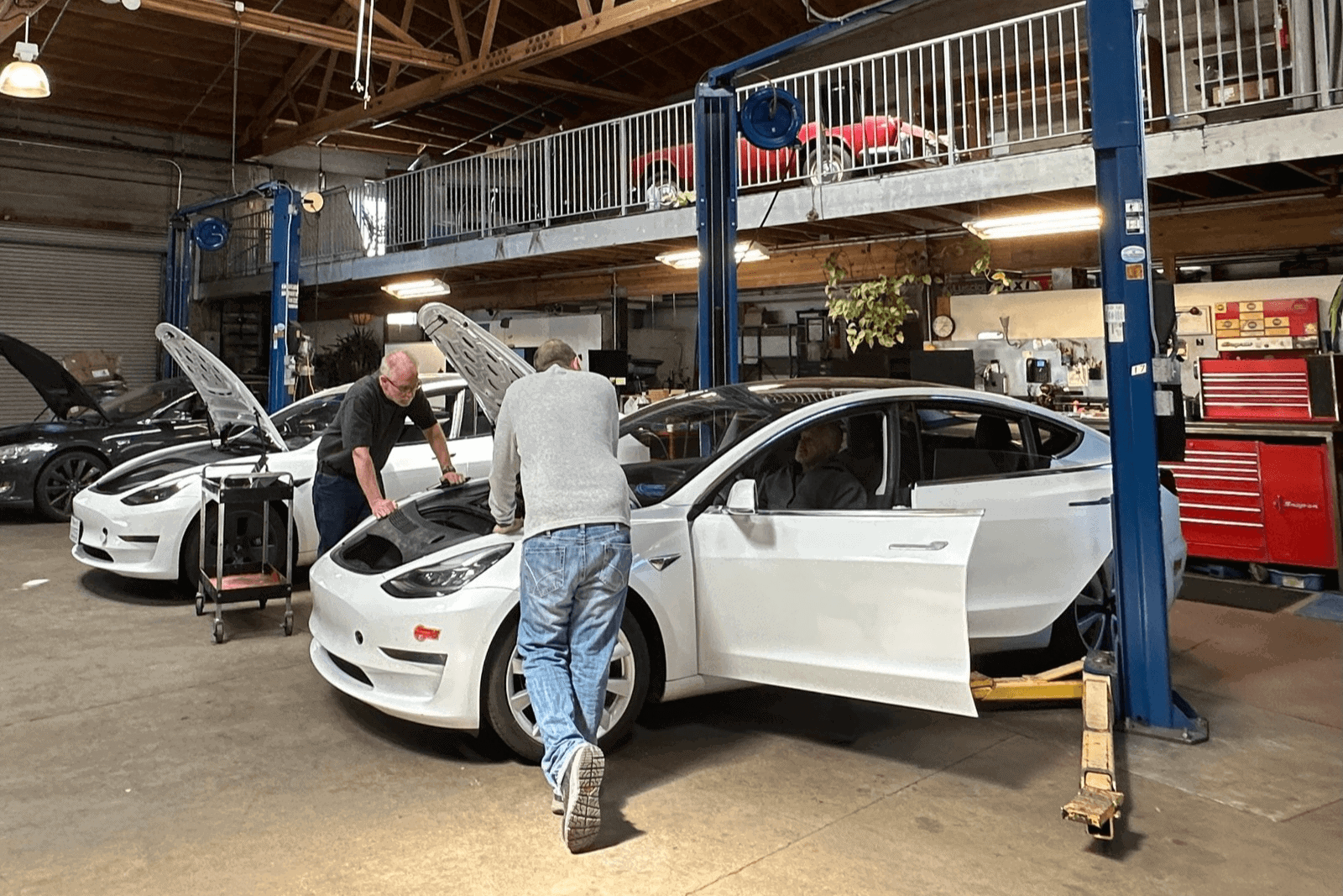 Image showcasing Earthling Automotive technicians servicing a Tesla Model 3