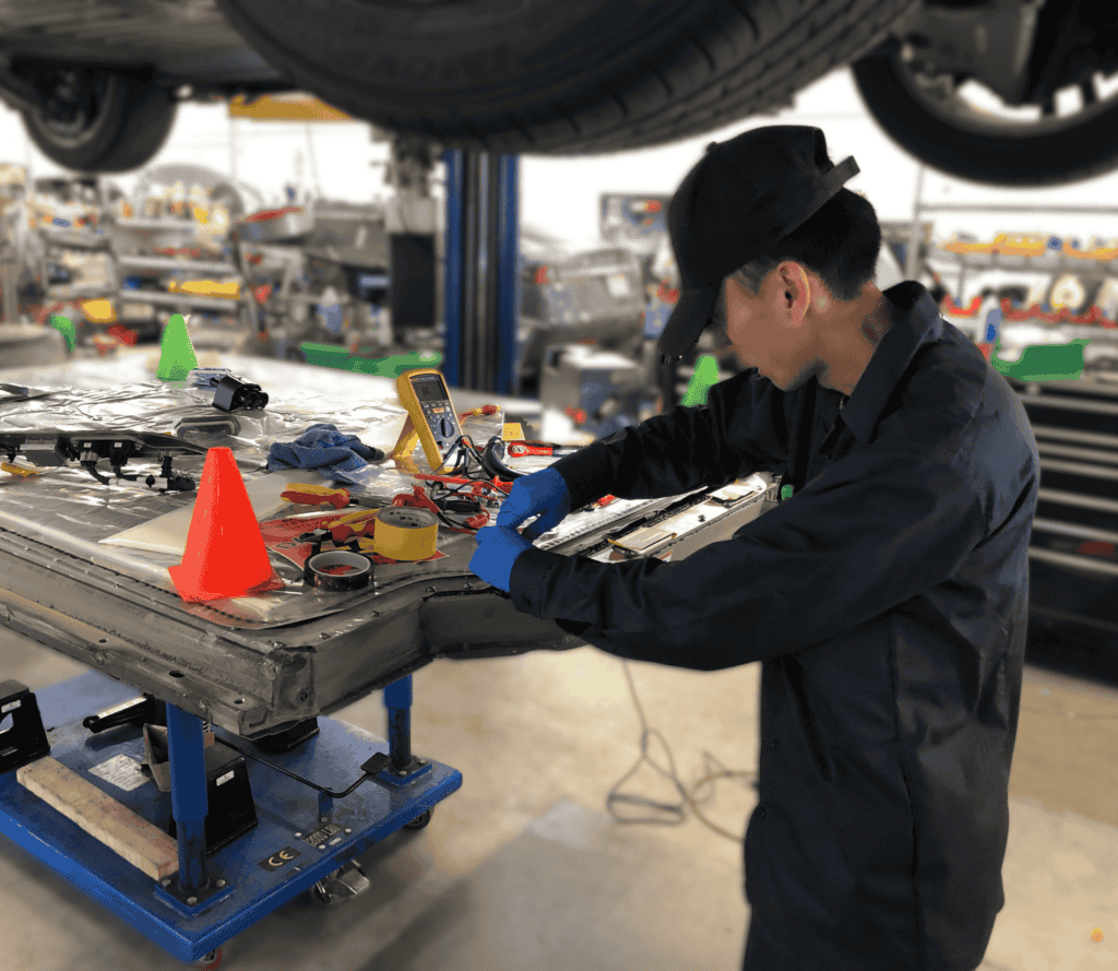 tesla battery replacement cost Earthling Automotive tech working on a high voltage battery