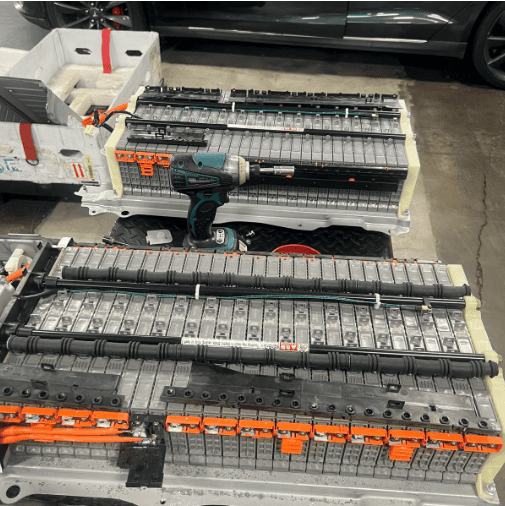 Prius HV battery replacement: original back in foreground showing corrosion on terminals; replacement back in background next to shipping packaging.