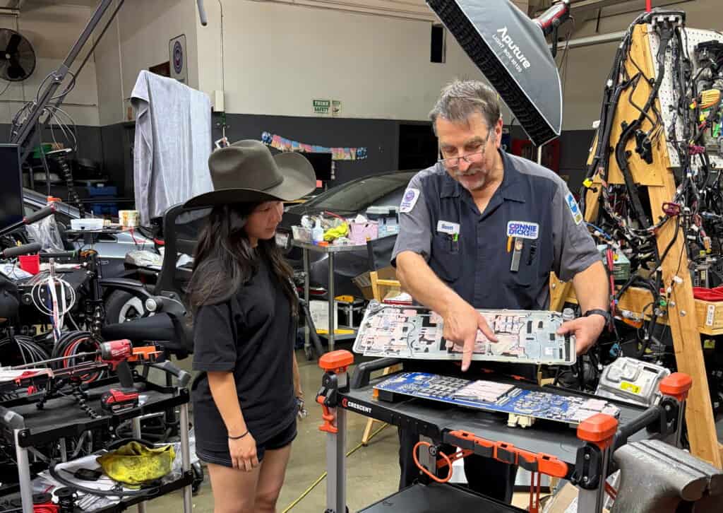 Scott Brown showing Grace a Tesla Cybertruck Power Conversion System board at Connie and Dick's